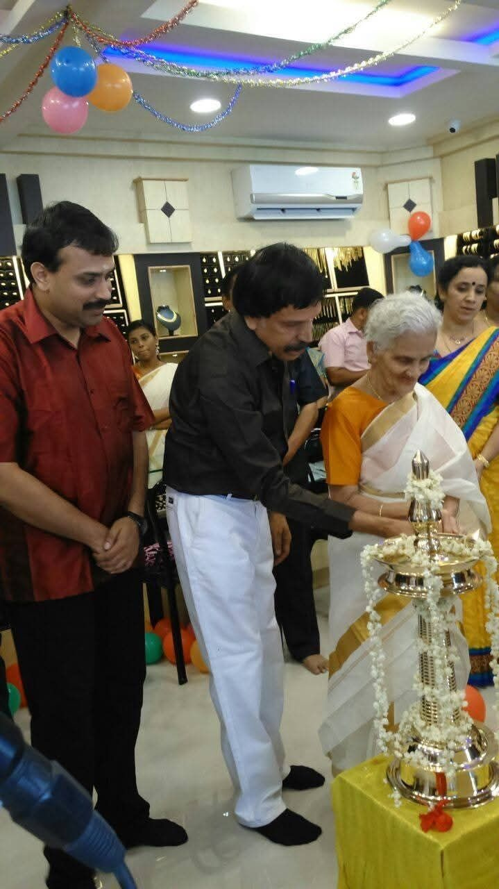 The family gathered as the eldest lights the nilavilakku at a Balakrishna Jewellery opening